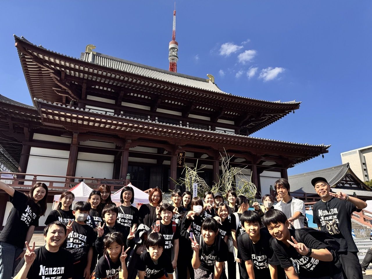 増上寺の大殿と東京タワーを背に集合した南山ジャズバンド(2024年)